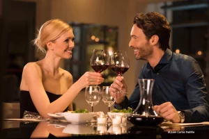 Un bonito enfado mujer y hombre chocando copas de vino